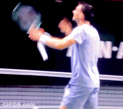 Blurry Man Holding Tennis Racket In Front Of N-A Sign GIF