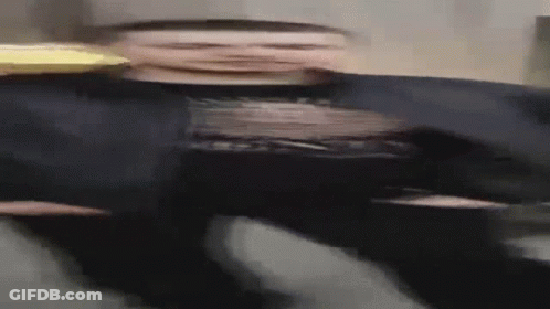Blurry Man In Black Shirt And Hat Holding Pizza GIF