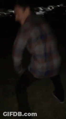 Blurry Man In Plaid Shirt In Dark GIF