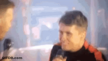 Blurry Man Talking Into Microphone With Onlooker GIF