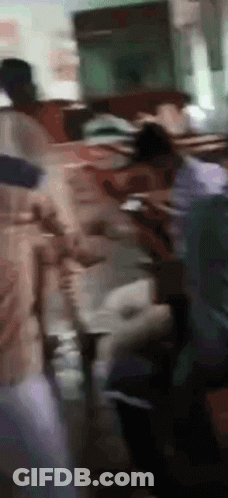 Blurry People Standing Around Table GIF