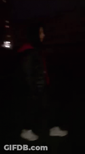 Blurry Person Behind Fence At Night GIF