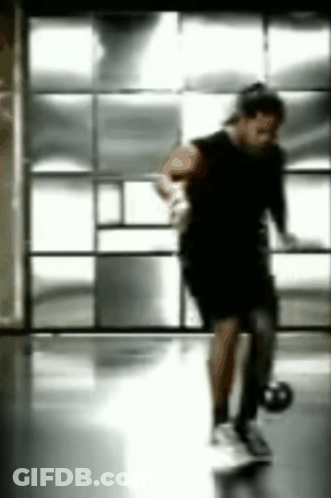 Blurry Person Holding Basketball In Gym GIF