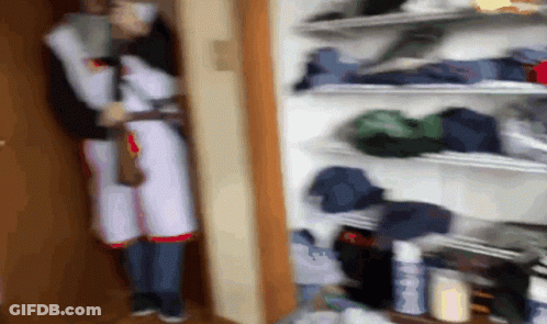 Blurry Person In Closet With Clothes GIF