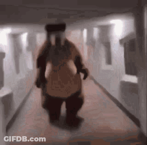 Blurry Person In Costume Walking Down Hallway GIF