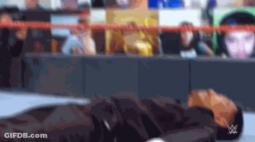 Blurry Person Laying On Ground With Wrestling Logo GIF