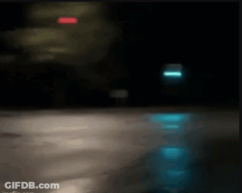 Blurry Person Riding Bike Down Street At Night GIF