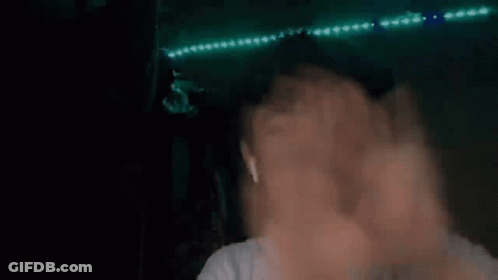 Blurry Person's Face And Hands With Green Lights GIF