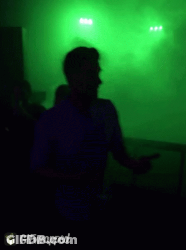 Blurry Picture Of Man Dancing In Front Of Green Background GIF