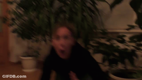 Blurry Woman Face In Front Of Bookshelf GIF
