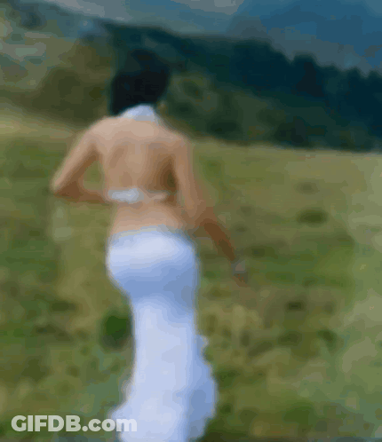 Blurry Woman In White Dress Walking In Field GIF