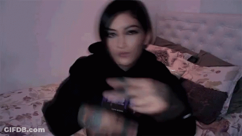 Blurry Woman Laying On Bed In Black Hoodie Saying Purple GIF