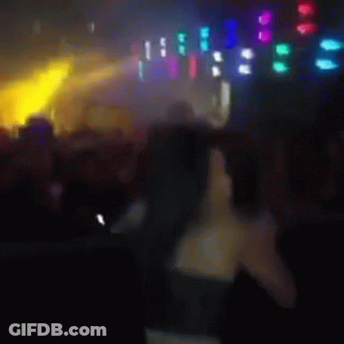 Blurry Woman Standing In Front Of Crowd GIF