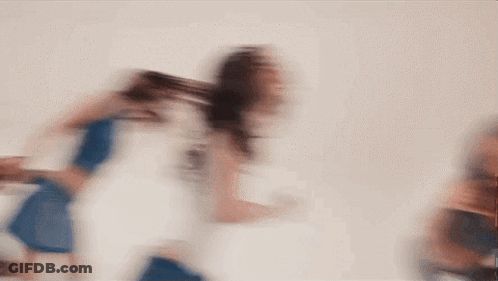 Blurry Woman Walking In Front Of White Wall GIF