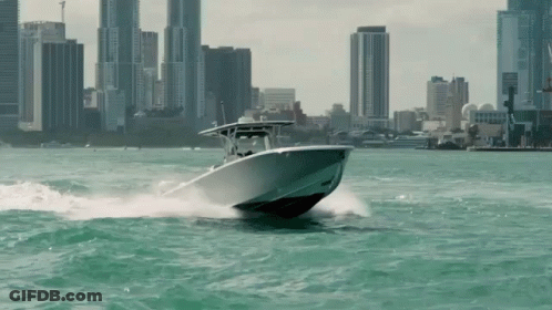 Boat Speeding Through Water With City Background GIF