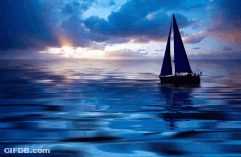 Boat With Blue Sails At Sunset GIF