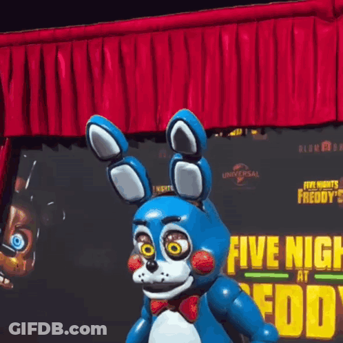 Bonnie The Bunny From Five Nights At Freddy's Standing In Front Of Red Curtain And Poster GIF