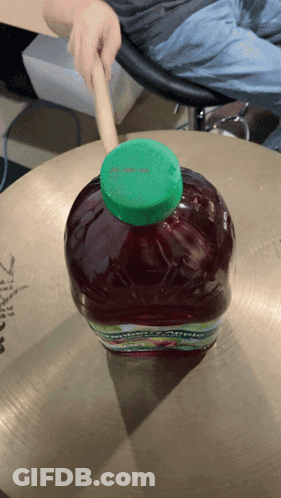 Bottle Of Apple Juice On Cymbal GIF