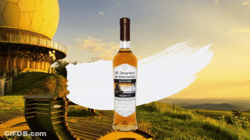 Bottle Of Chapter Ten In Front Of Yellow Building GIF