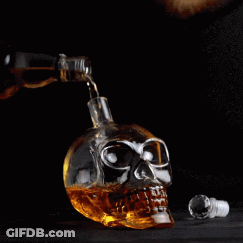 Bottle Pouring Alcohol Into Skull-Shaped Glass GIF