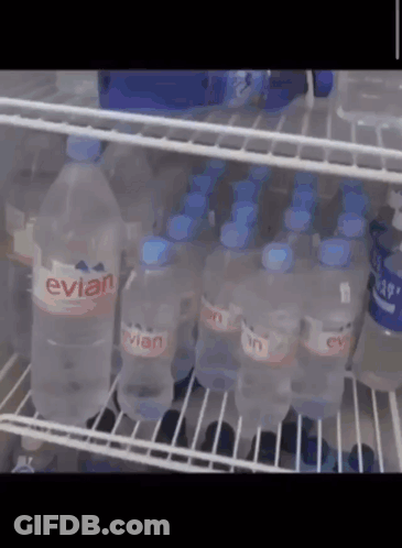 Bottles Of Evian Water Are Lined Up On A Shelf GIF