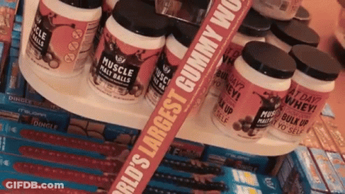 Bottles Of Muscle Mass Balls Are Stacked On A Shelf GIF