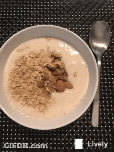 Bowl Of Yogurt With Oatmeal And Almonds Next To Spoon GIF