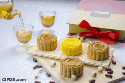 Box With Red Bow Next To Cakes GIF