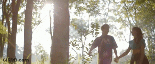 Boy And Girl Holding Hands In Woods GIF