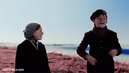 Boy And Girl In Field Of Pink Grass GIF