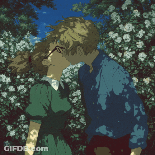 Boy And Girl Kissing In Front Of Flowers GIF