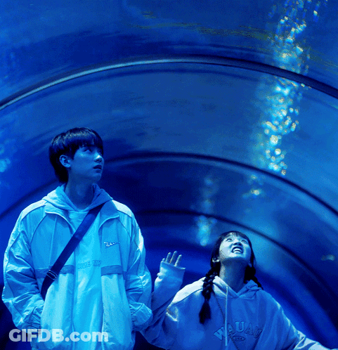 Boy And Girl Looking Up At Water In Tunnel GIF