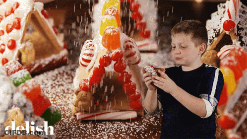 Boy Decorating Gingerbread House With Candy Canes GIF