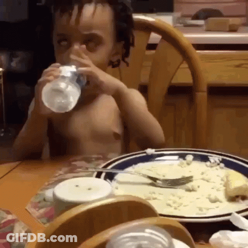 Boy Drinking Water From Bottle At Table With Food GIF