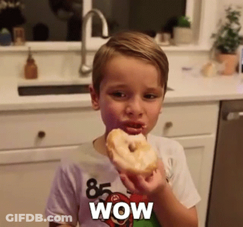 Boy Eating Donut With Wow Shirt GIF