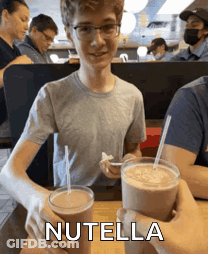 Boy Holding Two Milkshakes With Nutella GIF