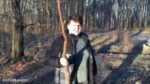 Boy In Black Jacket Holding Tree Branch GIF