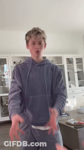 Boy In Blue Hoodie Standing In Living Room GIF