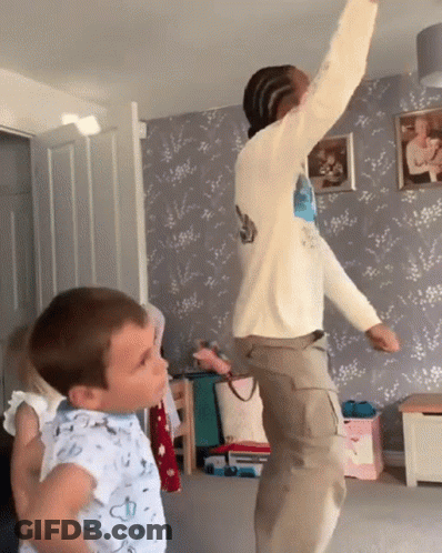 Boy In Blue Shirt Next To Jumping Man GIF