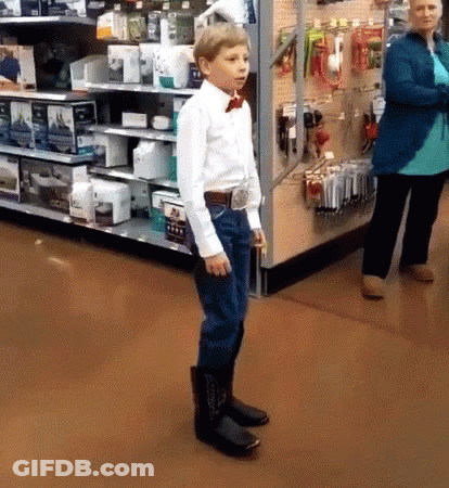 Boy In Cowboy Boots And Bow Tie Standing In Store GIF