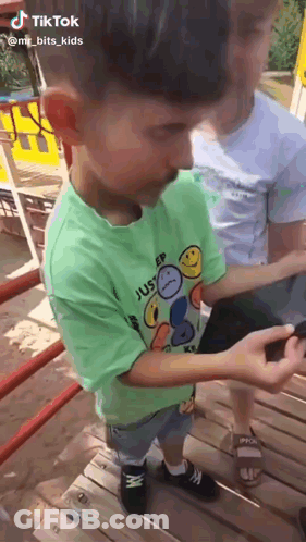 Boy In Green Sleep Shirt Looking At Phone GIF