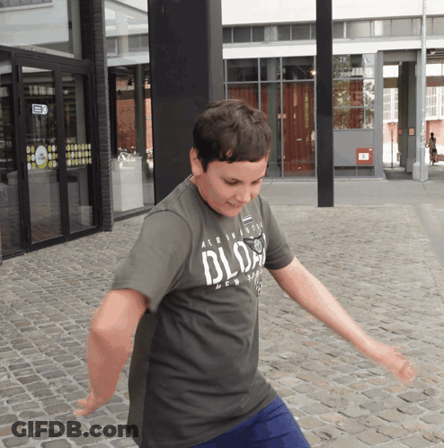 Boy In Grey Aeropostale Shirt Dancing On Cobblestone Street GIF