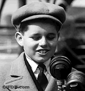 Boy In Hat And Tie Talking Into Microphone GIF
