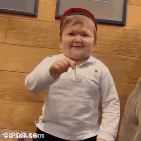 Boy In Hat Smiling Holding Toothpick GIF