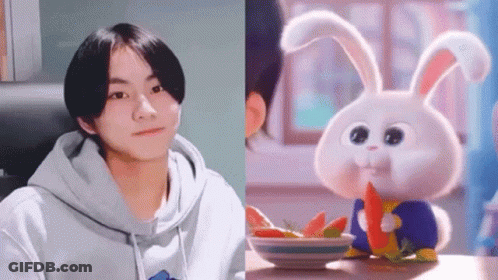 Boy In Hoodie Next To Rabbit Eating Carrot GIF