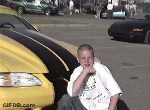 Boy In I Am A Los Angeles Shirt Next To Yellow Car GIF