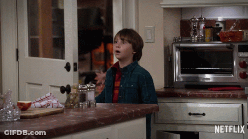 Boy In Kitchen With Netflix Logo On Counter GIF