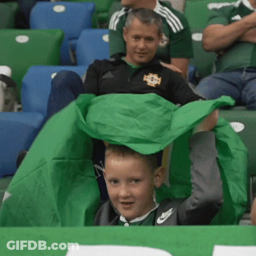 Boy In Nike Shirt Holding Green Cloth GIF