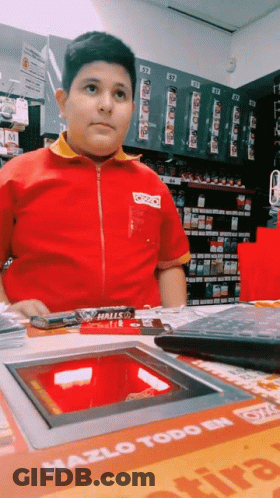 Boy In Red And Yellow Uniform In Front Of Machine Saying Hazlo Todo GIF