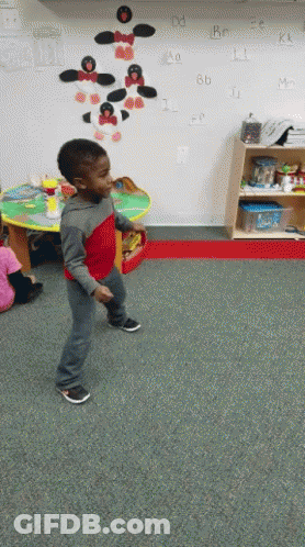 Boy In Red Shirt Dancing In Front Of Alphabet Wall GIF